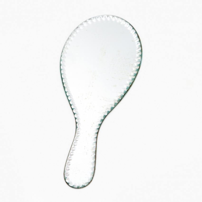 Miroir à poignée gravé de motifs géométriques.