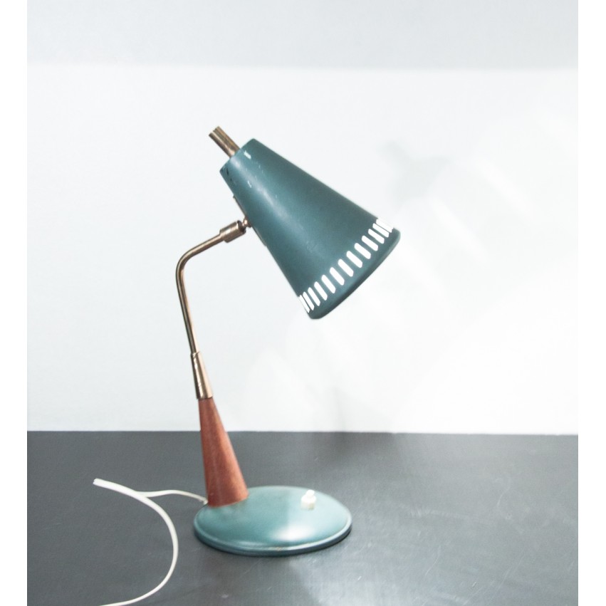 Petite lampe de bureau en fer, laiton et bois comportant un réflecteur conique aux perforations oblongues.