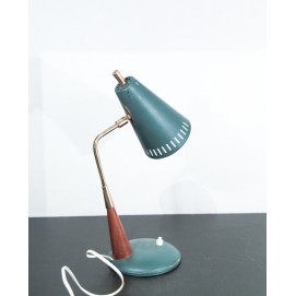 Petite lampe de bureau en fer, laiton et bois comportant un réflecteur conique aux perforations oblongues.