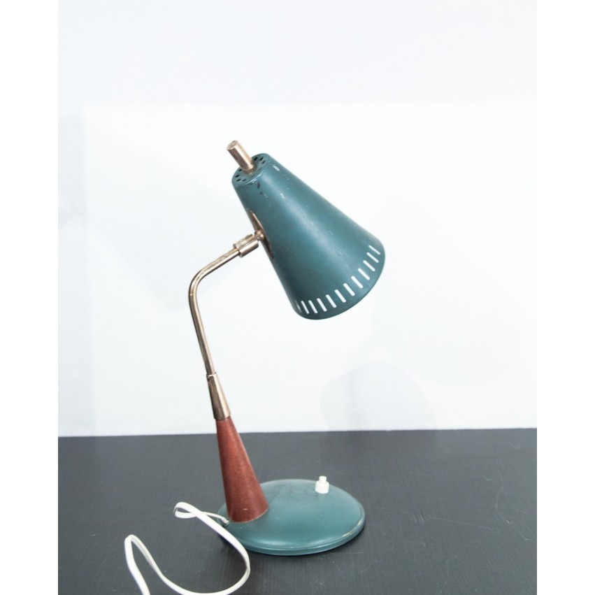 Petite lampe de bureau en fer, laiton et bois comportant un réflecteur conique aux perforations oblongues.
